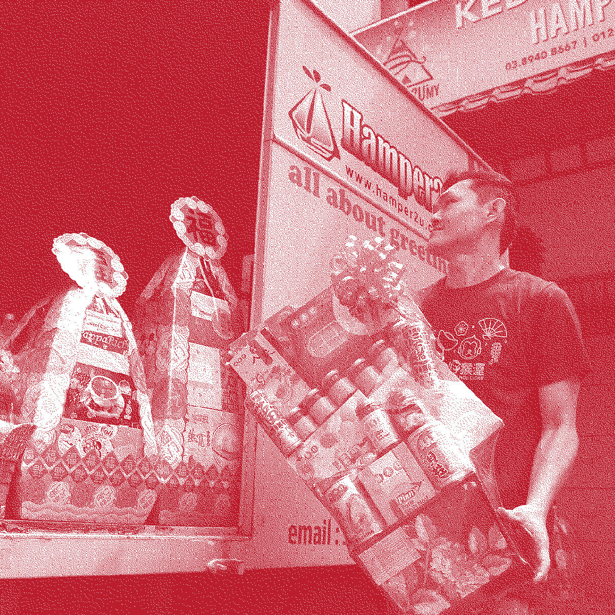 Person holding a large box of Hamper products with a store in the background