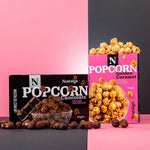 Nostalgia Popcorn and Popcorn Chocolate packages on a pink and black background