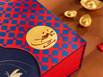 Red and blue checkered envelope with gold stamp on a brown surface