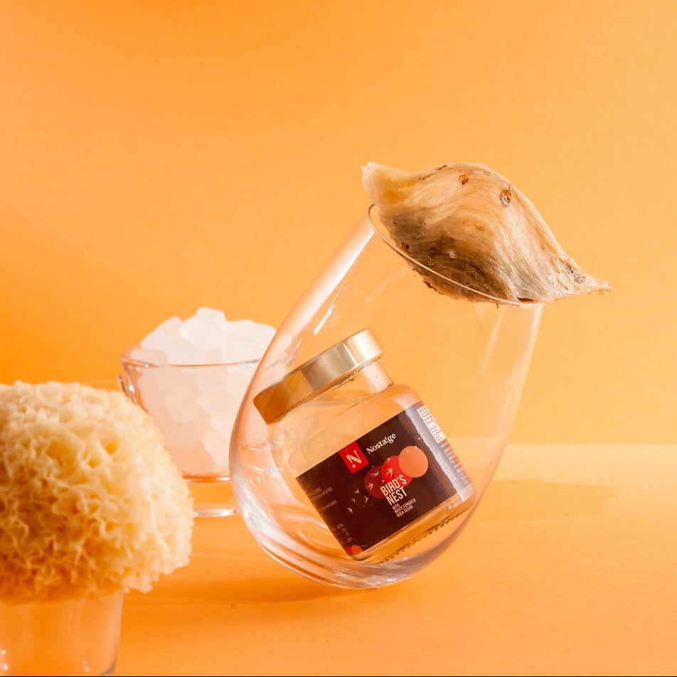 Clear glass teapot with a tea bag on an orange background