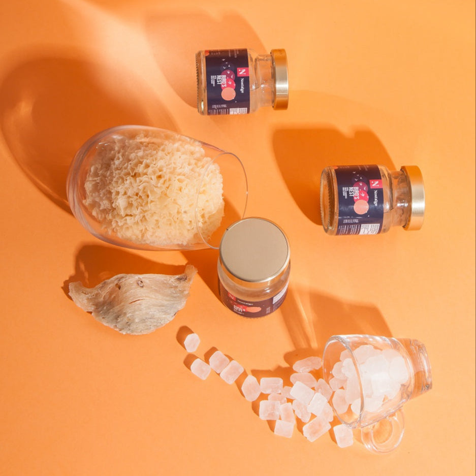 Jars of bird's nest and a glass container on an orange background