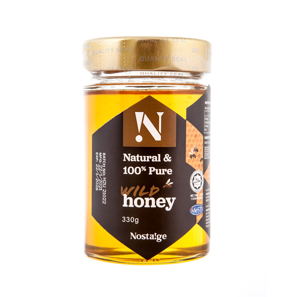 Jar of Nostalge wild honey with a gold lid on a white background