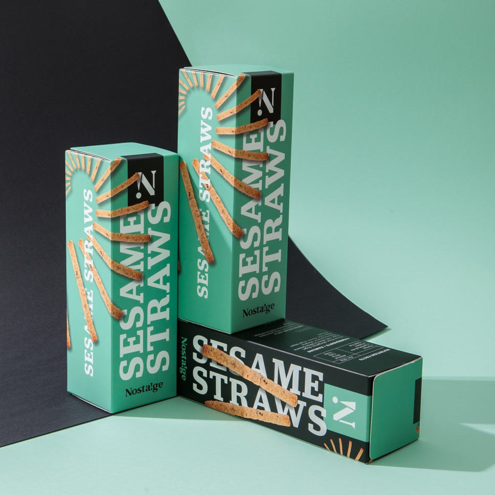 Three boxes of Sesame Straws on a green and black background