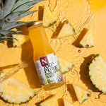 Bottle of 100% Pure Pineapple Juice with pineapple slices on a yellow background