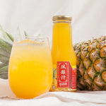 Pineapple juice bottle with a glass of juice and a pineapple on a light background