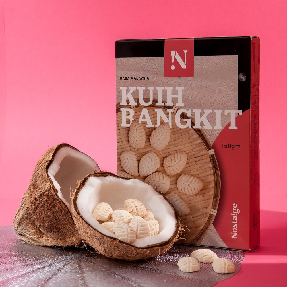 Kuih Bangkit packaging with a coconut and cookies on a pink background
