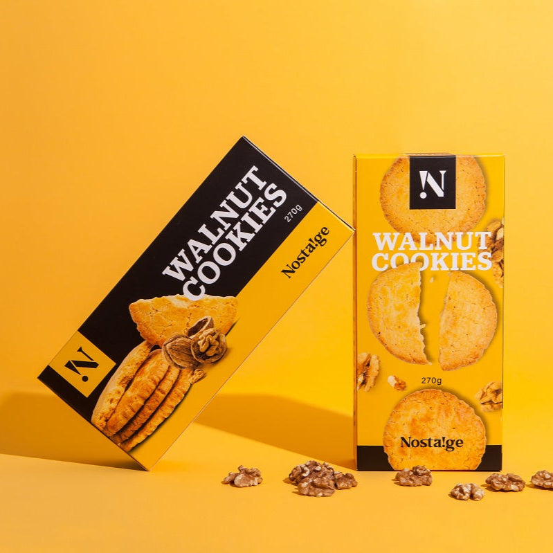 Two boxes of Nostalgia Walnut Cookies on a yellow background